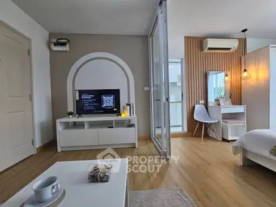 Modern living room with stylish decor and cozy bedroom in open layout apartment.