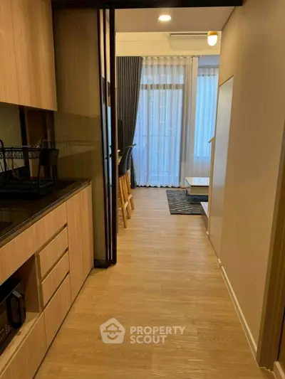 Modern open-layout kitchen with wooden flooring and sleek cabinetry