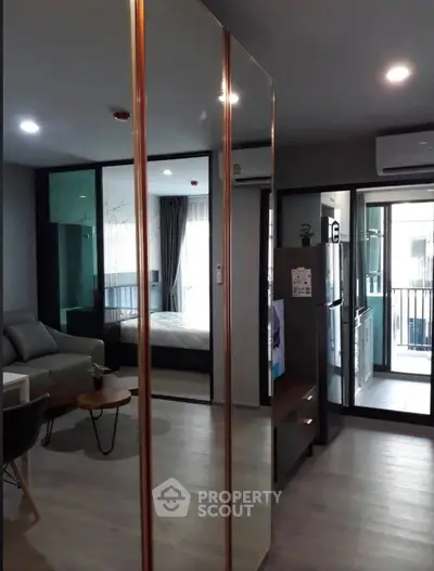 Modern apartment interior with open layout, featuring living room, kitchen, and bedroom with balcony access.