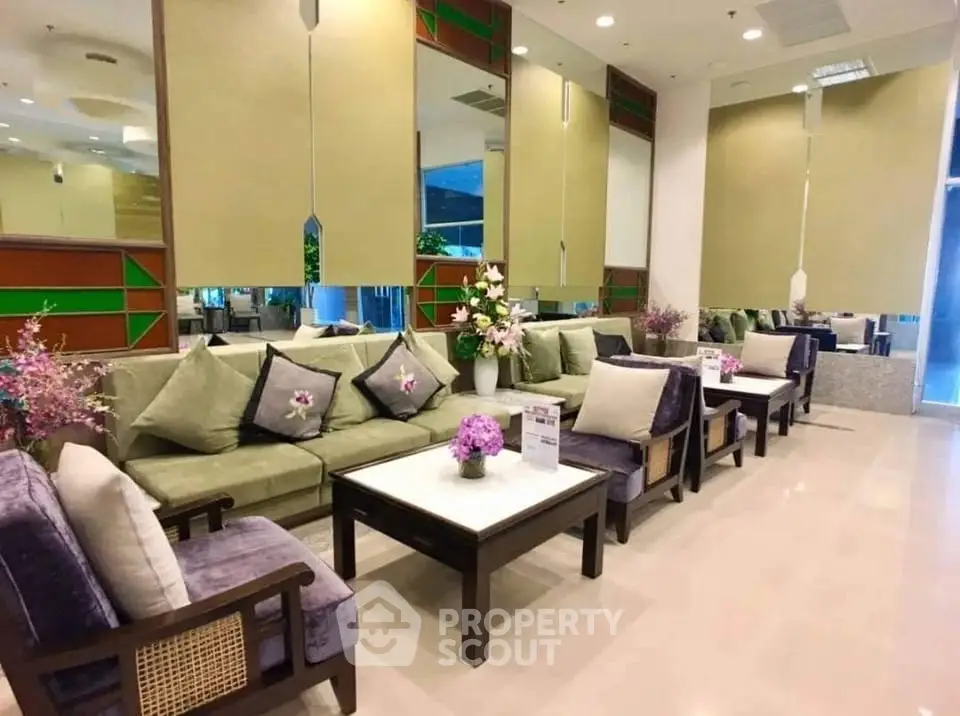 Elegant living room with plush seating and decorative mirrors in a modern apartment.