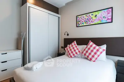 Charming bedroom with modern decor and vibrant artwork, featuring cozy bed and ample storage.