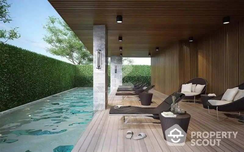 Luxurious modern poolside area with stylish lounge chairs and lush greenery.