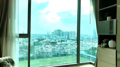 Stunning cityscape view from a modern high-rise apartment with floor-to-ceiling windows.