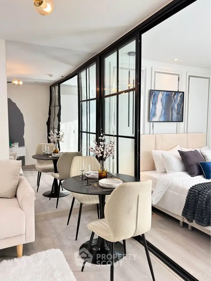 Modern open-plan living and bedroom area with stylish decor and glass partition.