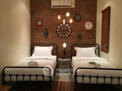 Charming twin bedroom with exposed brick wall and vintage decor accents.