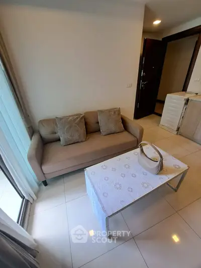 Cozy living room with beige sofa and elegant coffee table in modern apartment.