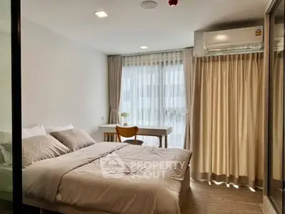 Modern bedroom with large window, cozy bed, and stylish decor in a bright apartment.