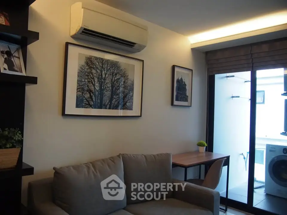 Modern living room with air conditioning and balcony access, featuring stylish decor and natural light.