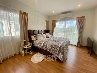 Spacious bedroom with large windows and elegant decor in modern home