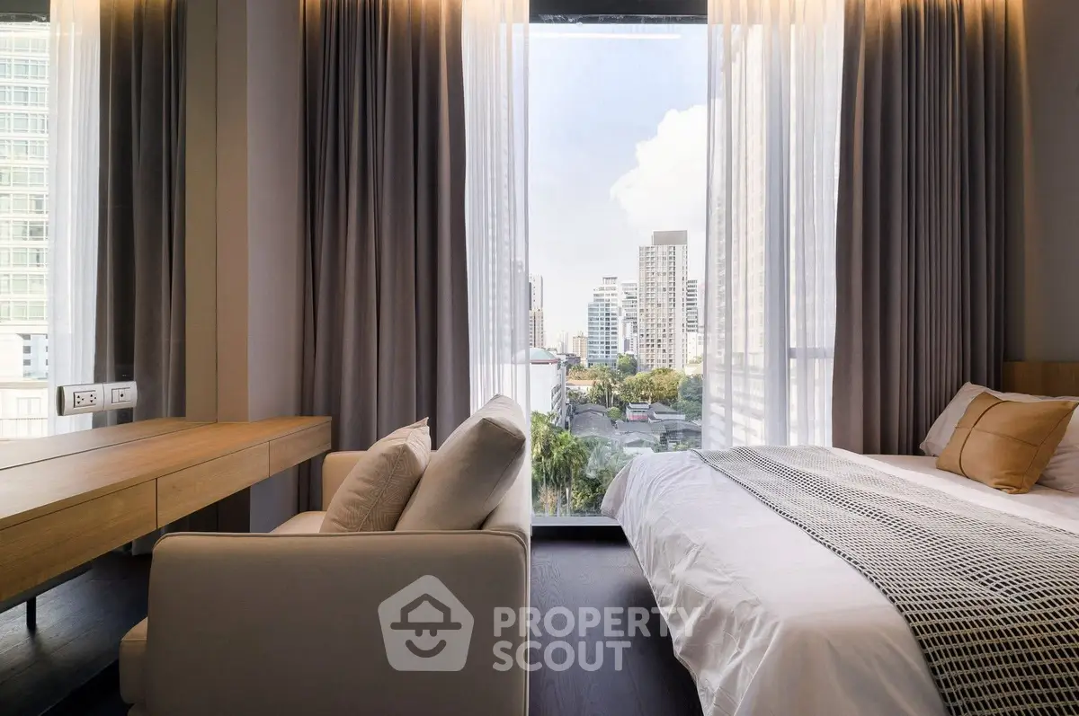 Modern bedroom with city view, featuring floor-to-ceiling windows and elegant decor.
