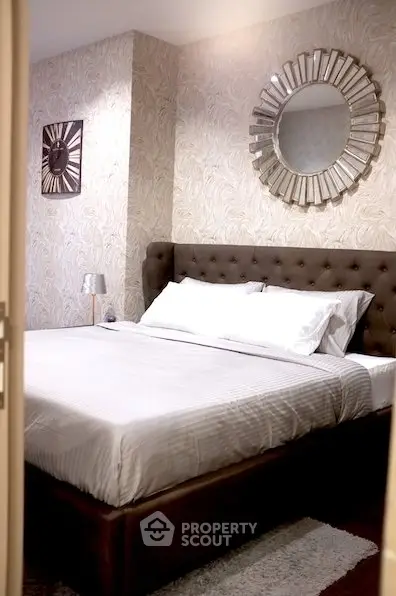 Elegant bedroom with tufted headboard and stylish wall mirrors