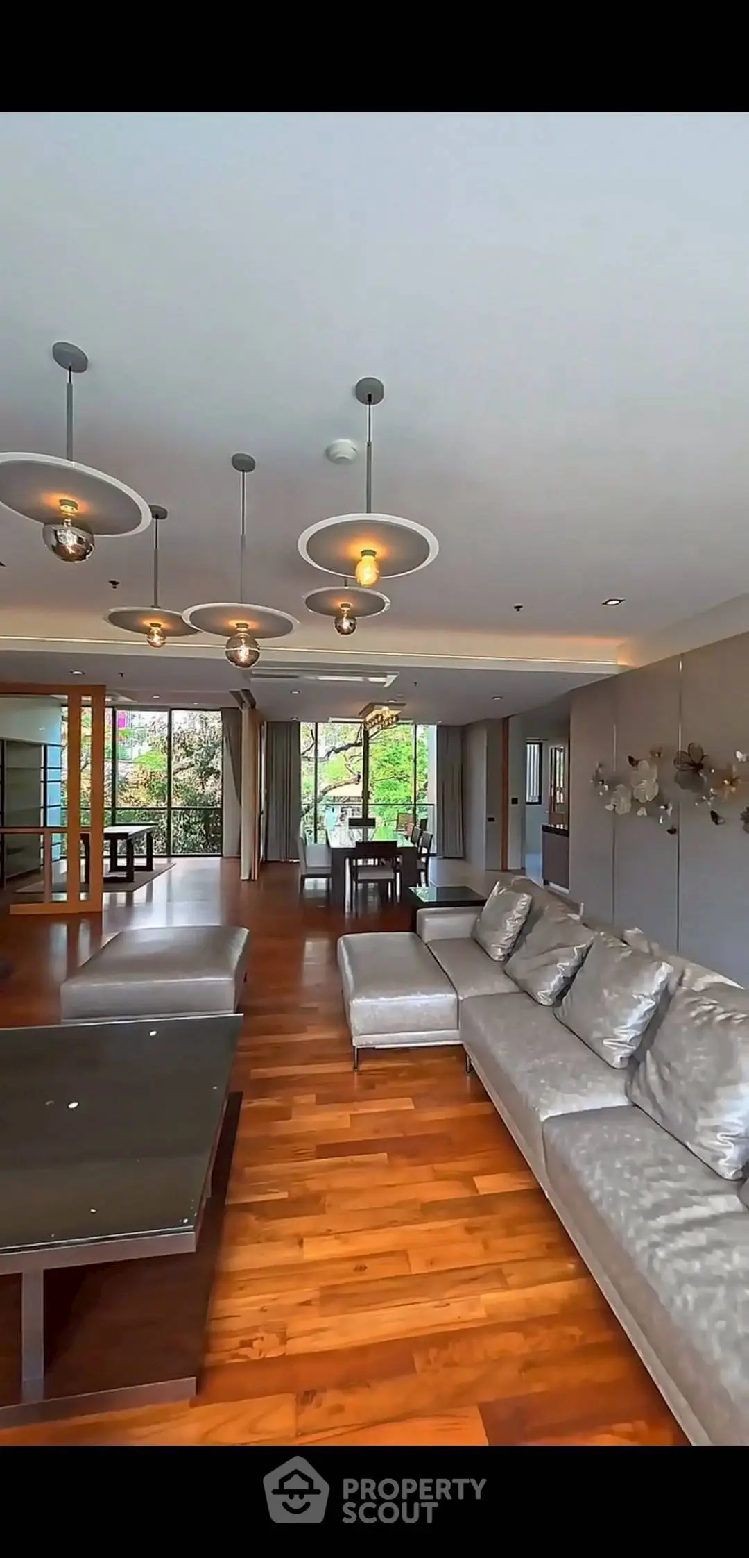 Luxurious living room with modern lighting and spacious layout, featuring elegant hardwood floors and stylish furniture.