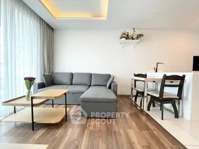 Modern living room with stylish gray sofa and elegant dining area