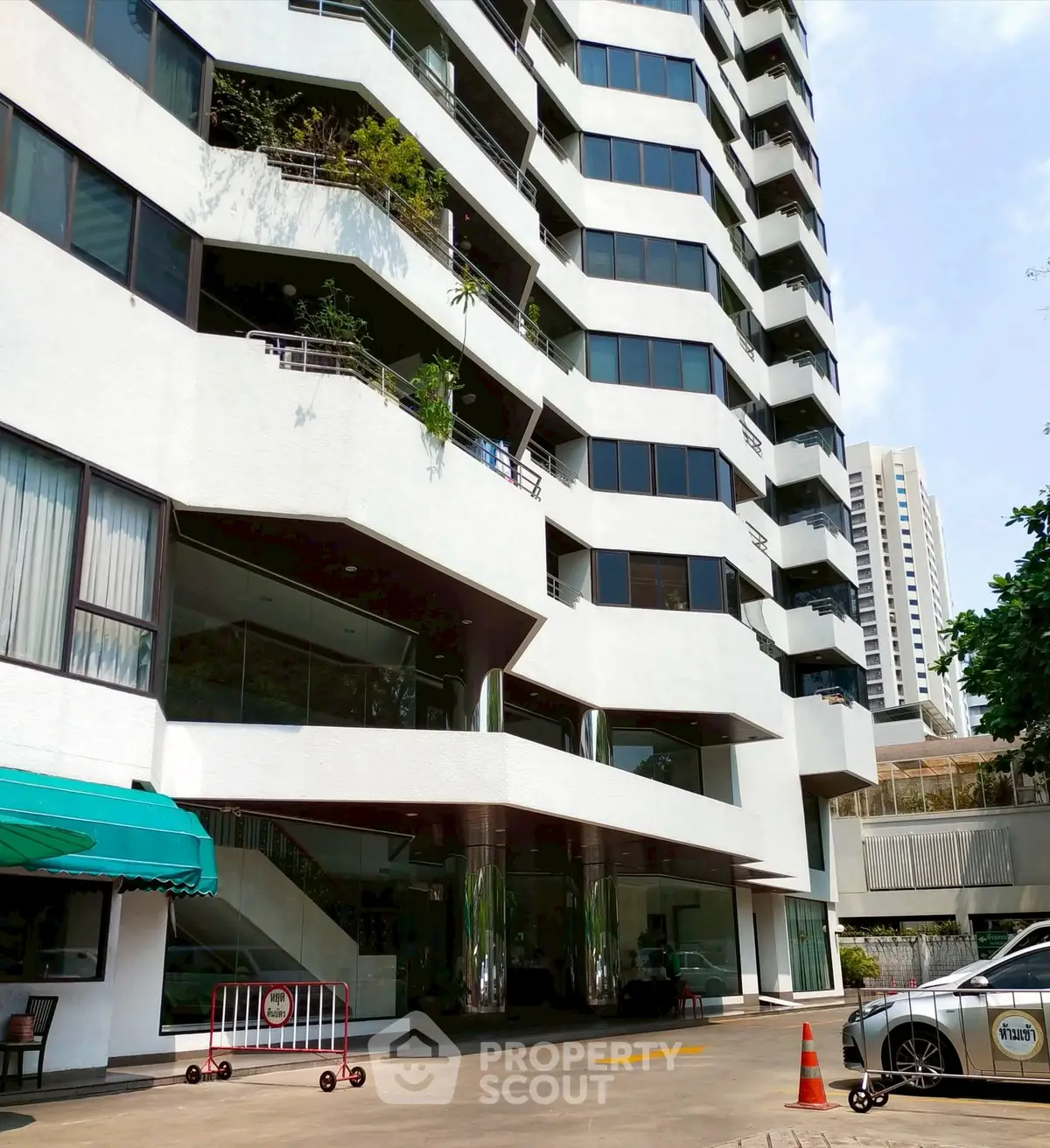 Modern multi-story building with unique architectural design and large windows in urban setting.