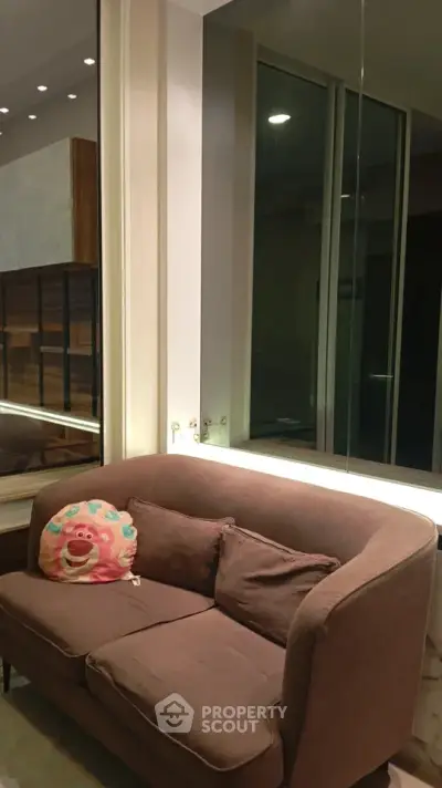 Cozy living room with plush sofa and large window, perfect for relaxation.
