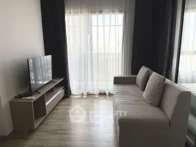 Modern living room with sleek sofa and TV, featuring floor-to-ceiling windows and elegant curtains.