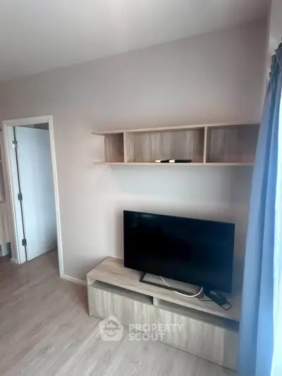 Modern living room with sleek TV stand and wall-mounted shelves, perfect for stylish urban living.