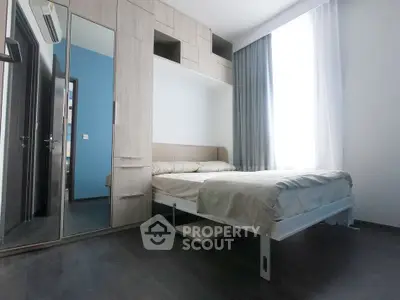 Modern bedroom with sleek design and ample natural light, featuring built-in storage and a cozy bed.