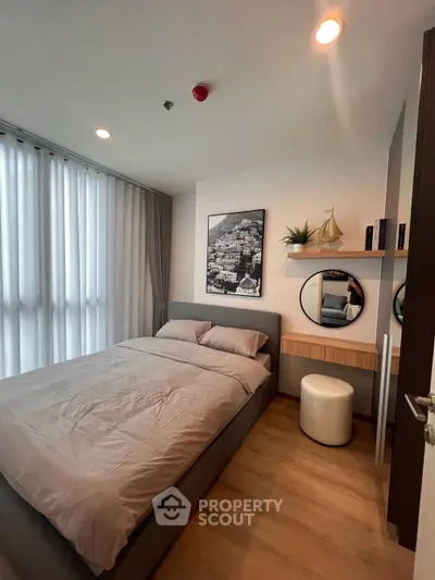 Modern bedroom with stylish decor and natural light, featuring a cozy bed and elegant furnishings.