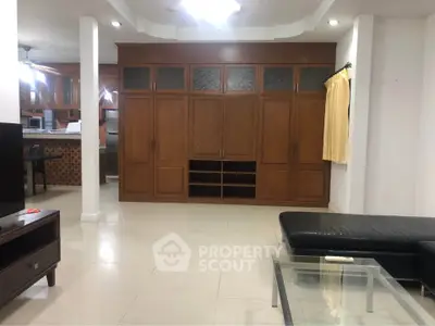 Spacious living room with built-in wooden cabinets and modern furniture