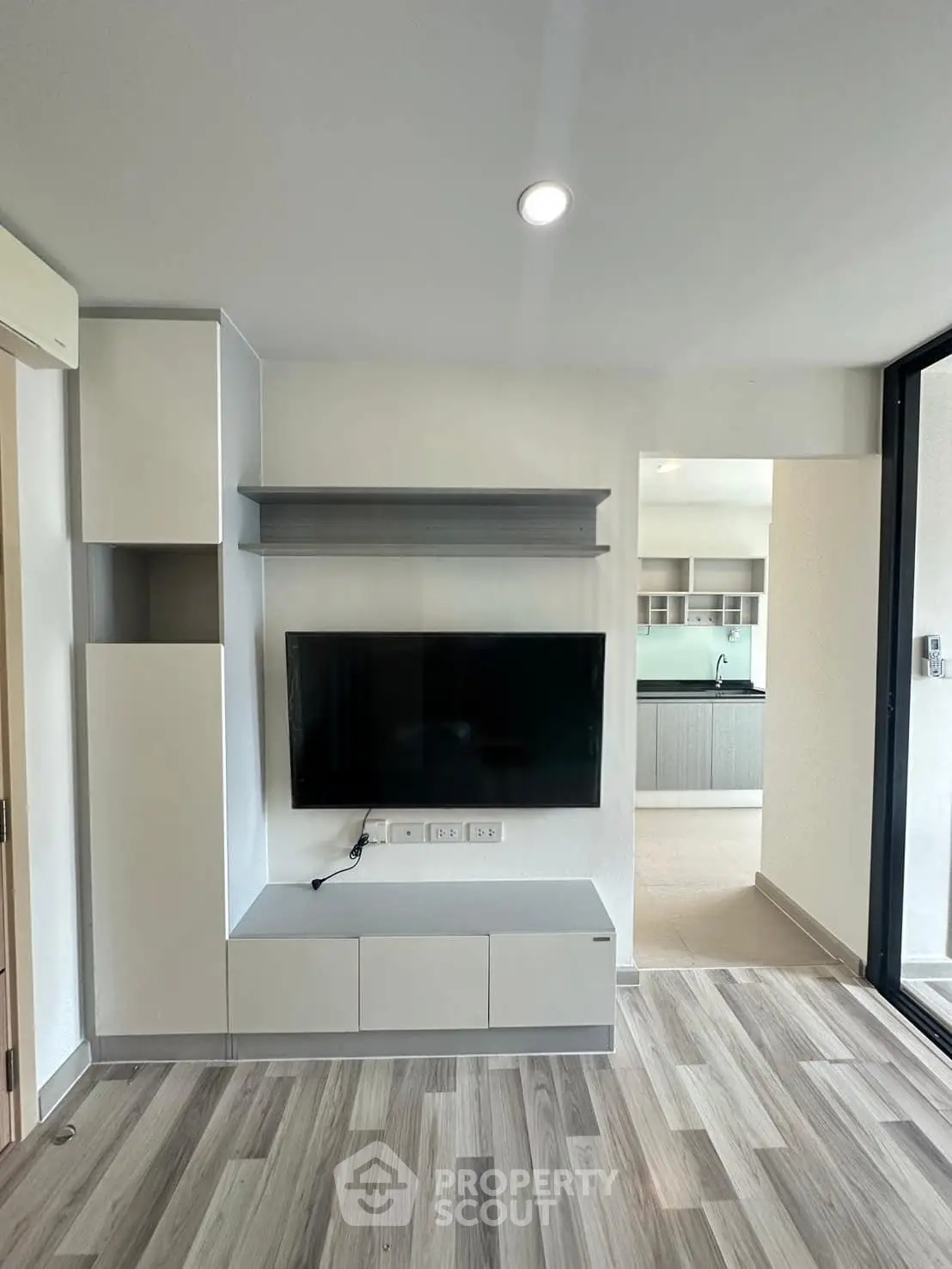 Modern living room with sleek TV unit and open kitchen view
