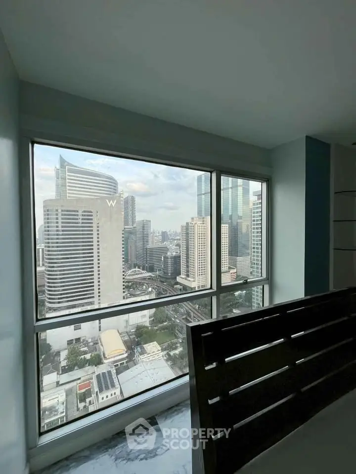 Stunning cityscape view from a high-rise apartment window, showcasing modern urban living.