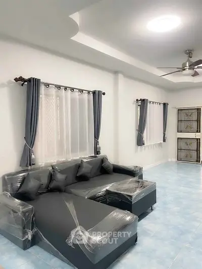 Modern living room with sleek gray sofa and elegant curtains, perfect for stylish comfort.