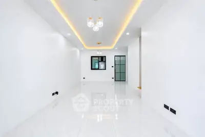 Spacious modern living room with elegant lighting and glossy white flooring