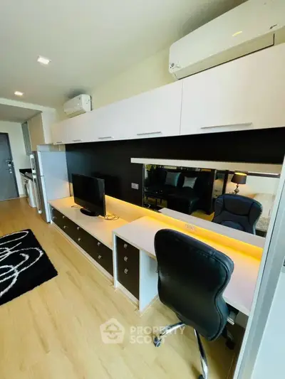 Modern living room with sleek furniture and built-in storage, featuring a stylish workspace and ambient lighting.