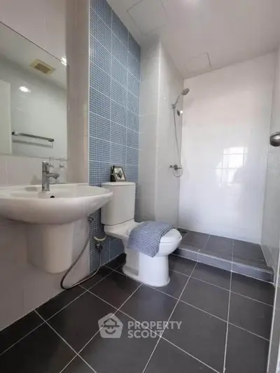 Modern bathroom with sleek design, featuring a walk-in shower and stylish fixtures.