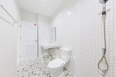 Modern white bathroom with hexagonal tiles and terrazzo flooring
