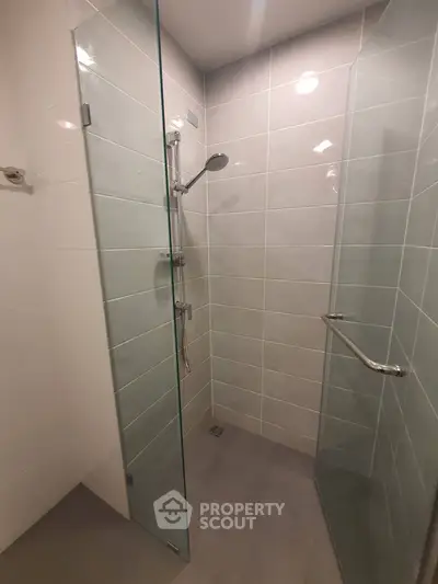 Modern bathroom with sleek glass shower enclosure and contemporary fixtures.