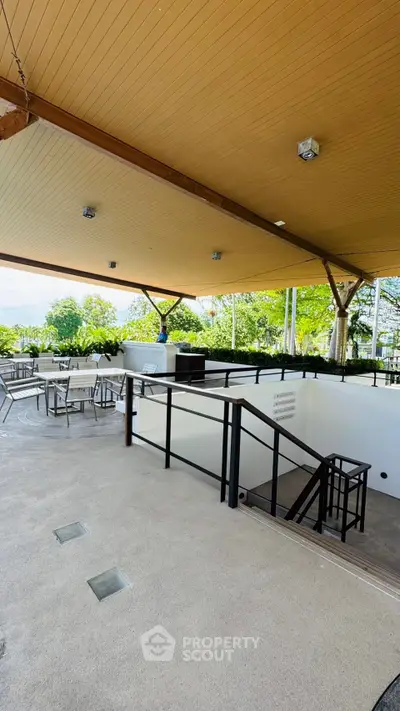 Spacious outdoor terrace with modern seating and lush greenery, perfect for relaxation and gatherings.