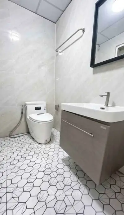 Modern bathroom with sleek fixtures and geometric tile flooring, perfect for contemporary living.