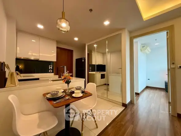 Modern kitchen with dining area and sleek design in a cozy apartment.