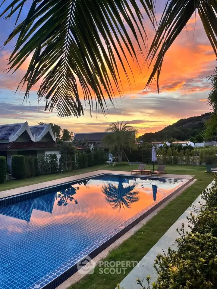 Stunning sunset view over luxurious pool in tropical garden setting