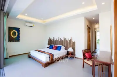 Luxurious modern bedroom with stylish decor and ample natural light, featuring a unique headboard design.