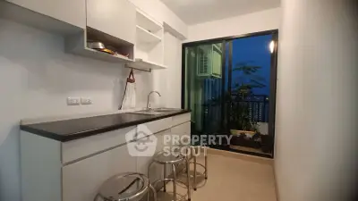 Modern kitchen with sleek cabinetry and balcony view