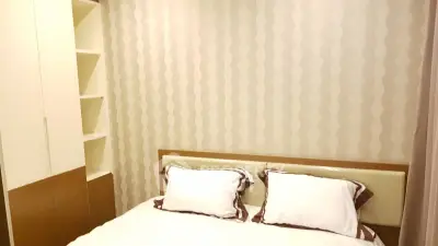 Cozy bedroom with modern design and built-in shelving, perfect for a comfortable living space.