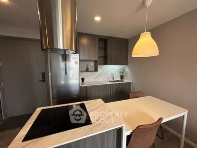 Modern kitchen with sleek design and open layout, featuring a stylish island and contemporary lighting.