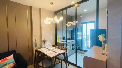 Modern apartment with stylish dining area and open kitchen layout, featuring elegant lighting and balcony access.