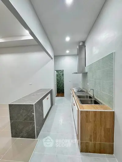 Modern kitchen with sleek design, featuring a double sink and stylish backsplash, perfect for culinary enthusiasts.