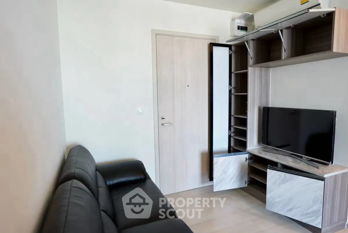Modern living room with sleek black leather sofa and stylish TV unit
