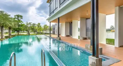 Luxurious modern home with stunning poolside view and spacious outdoor area.