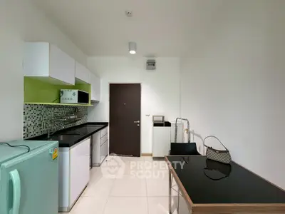 Modern compact kitchen with sleek cabinets and appliances in a minimalist design