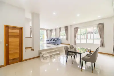 Spacious modern living room with elegant dining area and large windows.