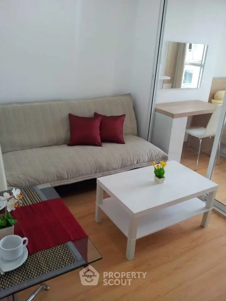 Cozy modern living room with sofa, coffee table, and dining area in a compact apartment.