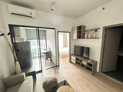Modern apartment interior with open living room and kitchen, featuring stylish decor and natural light.