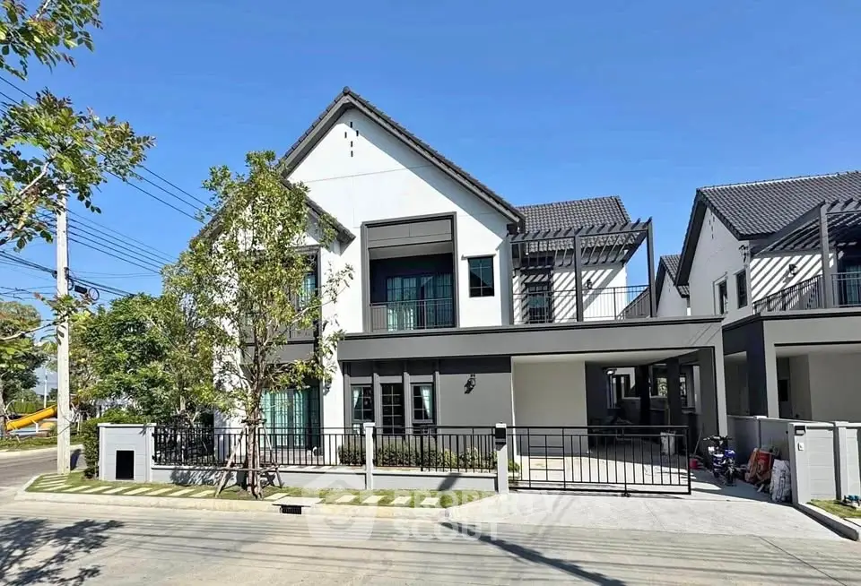 Modern two-story house with sleek design and spacious driveway in a serene neighborhood.