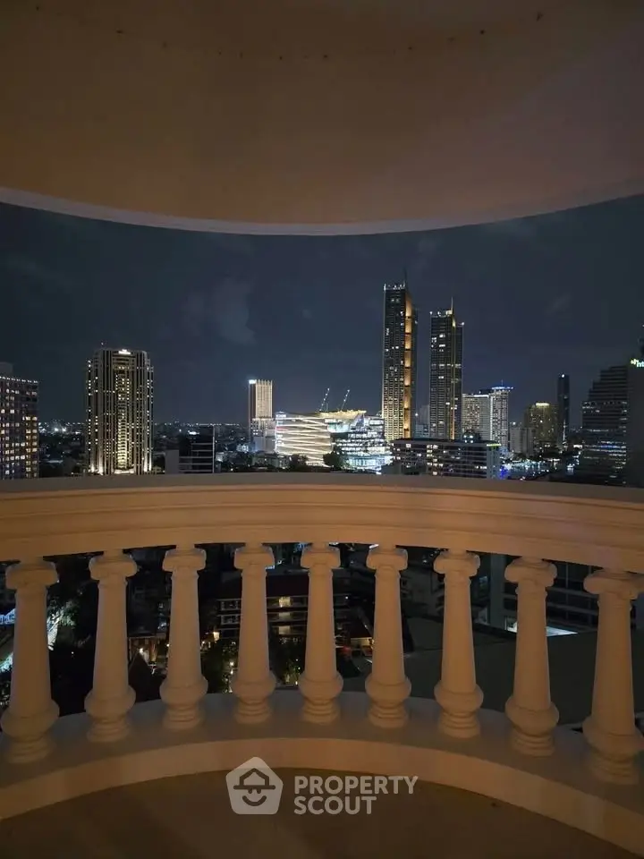 Stunning cityscape view from a balcony with elegant balustrade, showcasing vibrant night skyline.